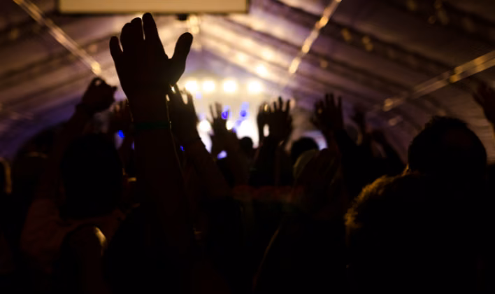 Colaboradores con las manos arriba en la pista de baile durante la hora loca de la fiesta de fin de año