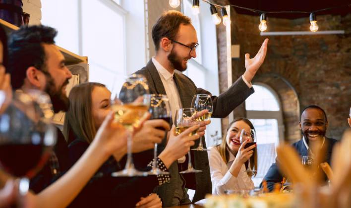 Presentador dirigiendo un brindis durante un evento corporativo organizado para una empresa