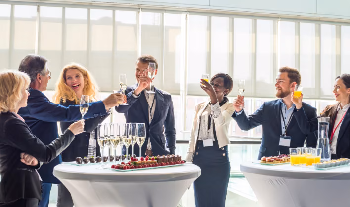 Invitados brindando en un cóctel corporativo bien organizado durante un evento empresarial
