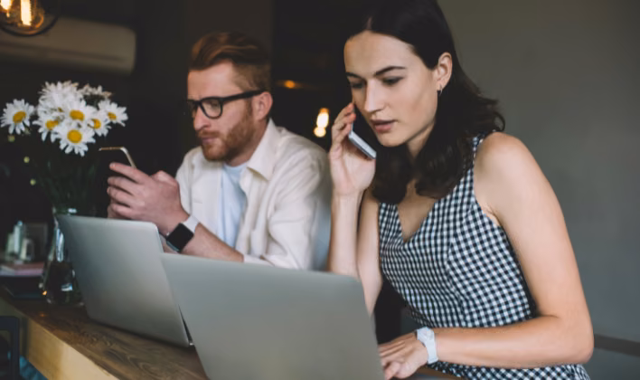 Colaboradores coordinando por teléfono y computador el presupuesto del evento de fin de año