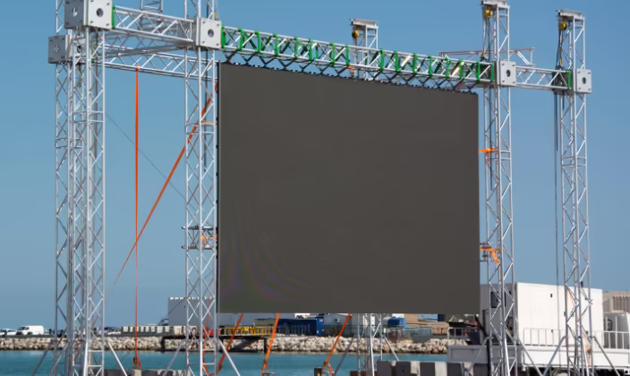Pantalla LED sostenida por una estructura truss autoportante con tensores, en un montaje al aire libre