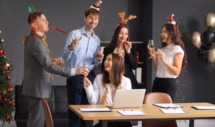 Colaboradores con gorros navideños definiendo el formato de la fiesta de fin de año en la oficina