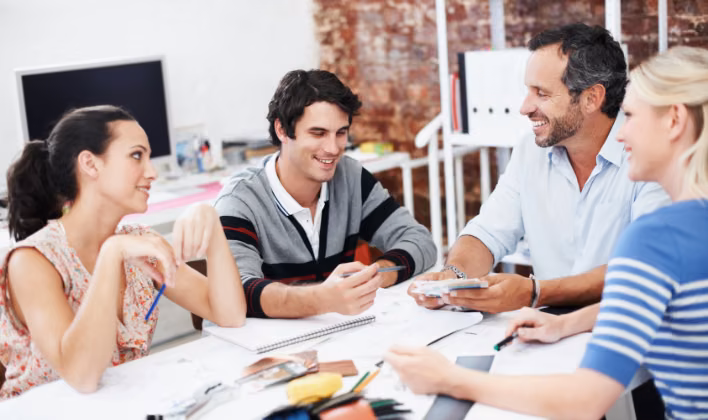 Equipo creativo diseñando el concepto de una convención empresarial temática con planos y bocetos