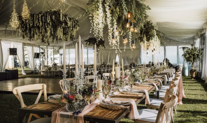 Mesa de banquete decorada con candelabros y flores para la fiesta de fin de año empresarial en Bogotá