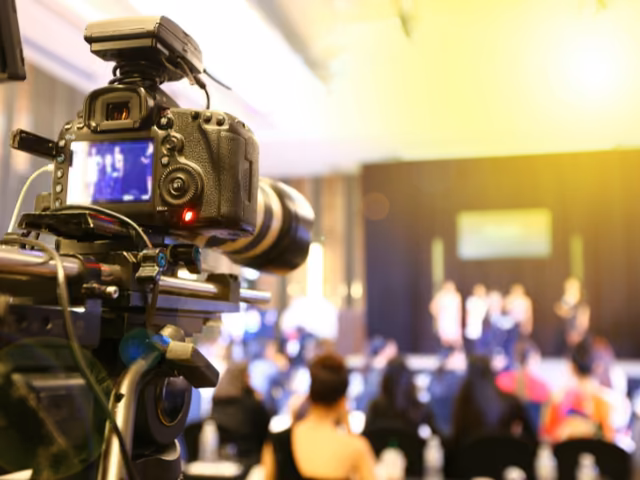 Cámara de video grabando la tarima de un evento corporativo para generar contenido digital
