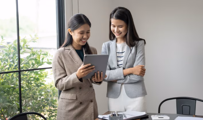 Dos profesionales de marketing revisando en una tablet los resultados de contenido digital de un evento