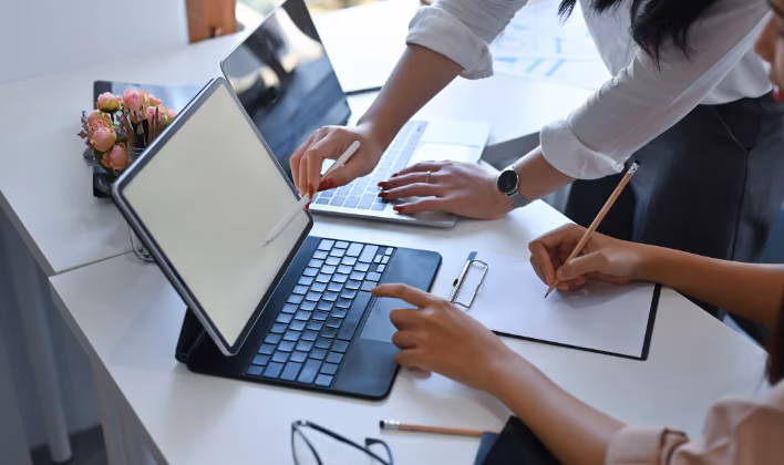 Equipo planeando la producción y la agenda de un congreso empresarial en una tablet