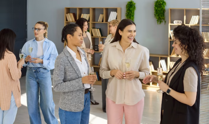 Equipo de colaboradoras brindando durante la celebración de un evento empresarial